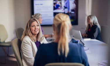 En grupp kvinnor som sitter runt ett konferensbord.