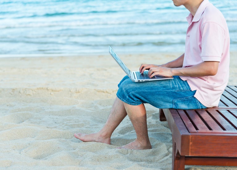 man med laptop pa strand