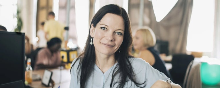 kvinna framfor dator i kontorslandskap