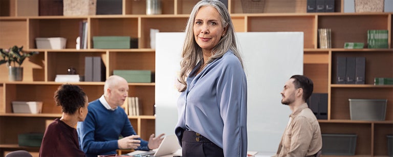 kvinna i fokus bland kollegor pa arbetsplats