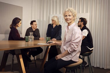 kollegor pa kontor med kvinna i forgrunden