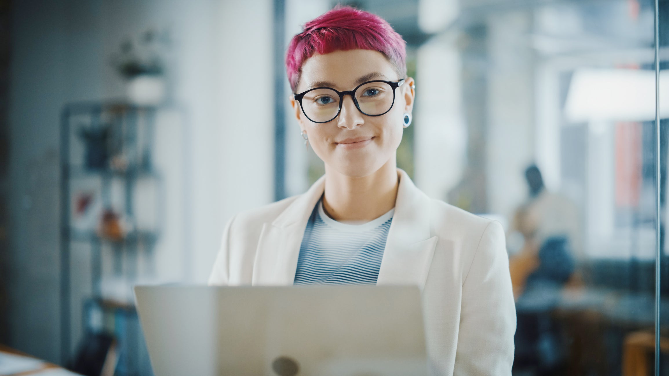 Foto på kvinna med rött hår och kavaj framför en dator.jpeg