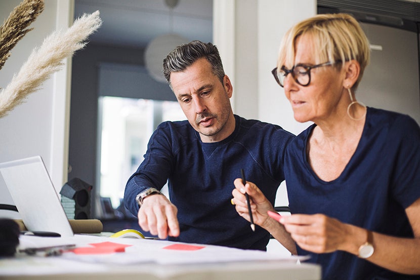 Foto på man och kvinna vid ett bord med dator framför sig.jpeg