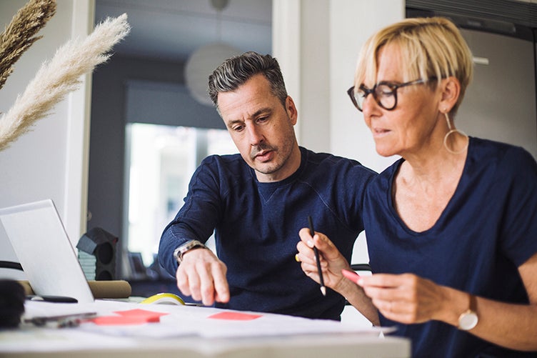 Foto på man och kvinna vid ett bord med dator framför sig.jpeg